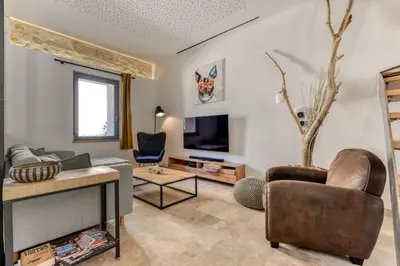 a living room with a couch and a tv at La Remise des Amis - Proche du centre du village in Peyriac-de-Mer