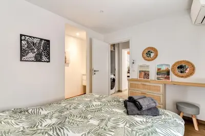 a bedroom with a large bed and a chair at La Remise des Amis - Proche du centre du village in Peyriac-de-Mer