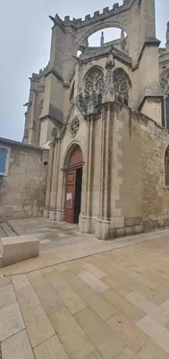 an old stone church with a red door at L'oiseau du paradis in Narbonne