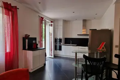 a kitchen with a table and chairs in a room at L'oiseau du paradis in Narbonne