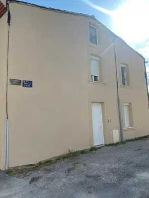 a white building with a sign on the side of it at Le Jungle in Pamiers