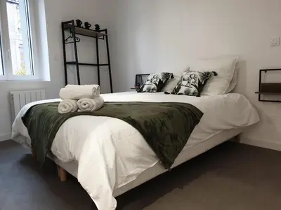 a bedroom with a large bed with towels on it at Le Jungle in Pamiers