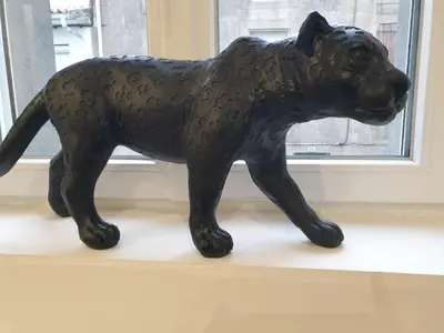 a statue of a black dog sitting on a window sill at Le Jungle in Pamiers