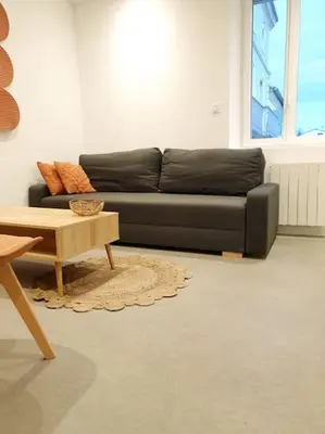a living room with a black couch and a coffee table at Le Bohème in Pamiers