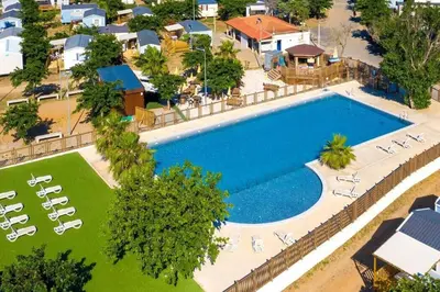 an overhead view of a large swimming pool with lounge chairs at MH148 camping NOVELA - location entre particuliers-Mobil home 6pl climatisé - in Port-la-Nouvelle