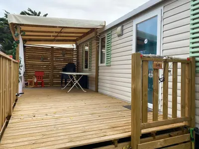 a wooden deck with a tent on top of a house at MH148 camping NOVELA - location entre particuliers-Mobil home 6pl climatisé - in Port-la-Nouvelle