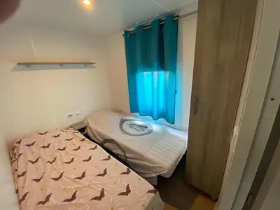 a small room with a bed and a window at MH148 camping NOVELA - location entre particuliers-Mobil home 6pl climatisé - in Port-la-Nouvelle