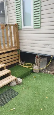 a house with a garden hose next to a house at MH148 camping NOVELA - location entre particuliers-Mobil home 6pl climatisé - in Port-la-Nouvelle