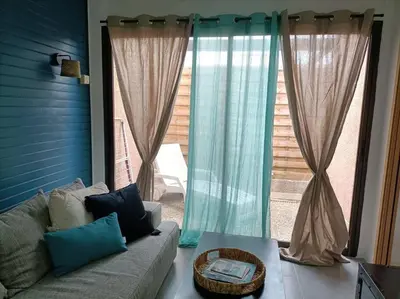 a living room with a couch and a large window at Le Sept in Gruissan