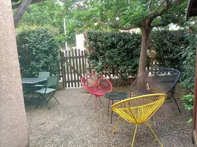a group of chairs and tables sitting next to a tree at Le Sept in Gruissan