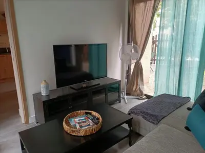 a living room with a television and a coffee table at Le Sept in Gruissan