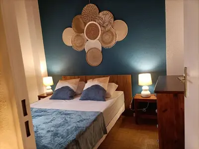 a bedroom with a bed with a blue wall at Le Sept in Gruissan