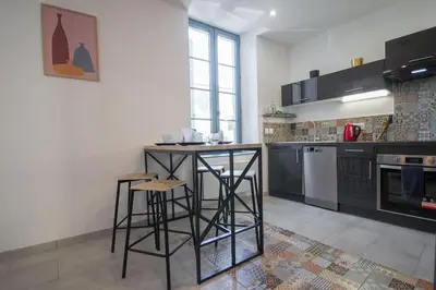 a kitchen with a counter and stools in it at L'As de Carreaux in Narbonne