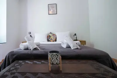 a bedroom with a large bed and a table at L'As de Carreaux in Narbonne
