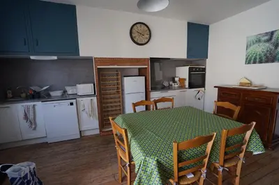 a bedroom with a bed and a table and a desk at La maison du Thoré in Saint-Amans-Valtoret