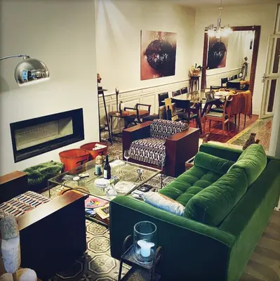 a living room with a green couch and a dining room at La Paloma La Palme in Lapalme