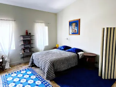 a bedroom with a bed and a blue rug at La Paloma La Palme in Lapalme