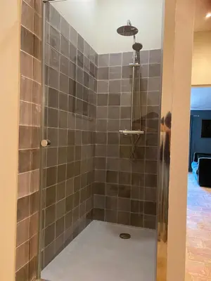 a man standing in a shower in a bathroom at La Paloma La Palme in Lapalme
