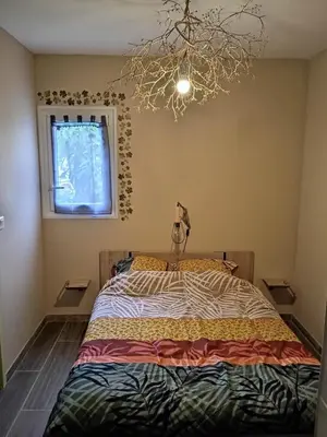a bedroom with a bed and a chandelier at Au soleil couchant in Villemoustaussou