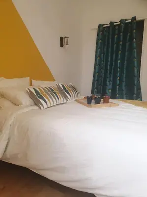 a bedroom with a white bed with a green headboard at Escapade détente au cœur de Pamiers in Pamiers