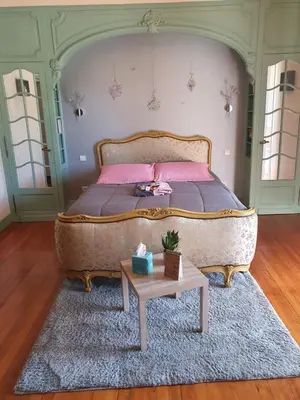 a bedroom with a large bed and a table at le lorrain in Saint-Pons