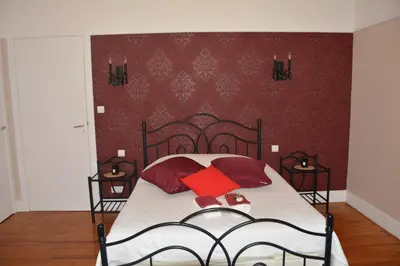 a bedroom with a bed with two red pillows at le lorrain in Saint-Pons
