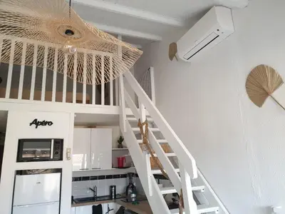 a white staircase in a kitchen with a ceiling at T2 plage place parking in Port-la-Nouvelle