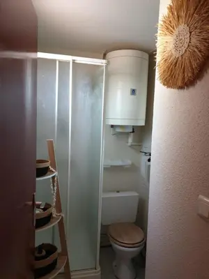 a small bathroom with a toilet and a cabinet at T2 plage place parking in Port-la-Nouvelle