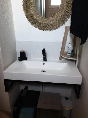 a white sink in a bathroom with a mirror at T2 plage place parking in Port-la-Nouvelle