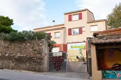 a building in front of a building with a wall at Gîte Les Mathouans in Latour-de-France