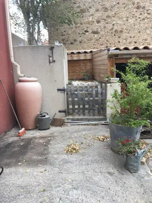 a backyard with a gate and some plants in pots at Gîte Les Mathouans in Latour-de-France