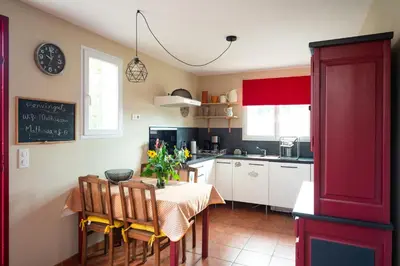 a kitchen with a table and chairs and a kitchen with a chalkboard at Gîte Les Mathouans in Latour-de-France