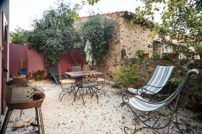 a patio with chairs and a table in a courtyard at Gîte Les Mathouans in Latour-de-France