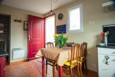 a kitchen with a table with a vase of flowers on it at Gîte Les Mathouans in Latour-de-France