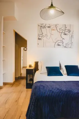 a bedroom with a large bed with blue pillows at 36 2 l air marin Penthouse Netflix Clim Free park Navette Grands Buffets Accès direct autoroute et plages in Narbonne