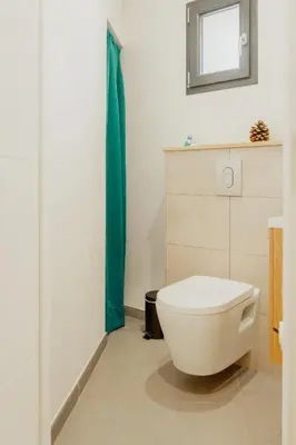 a bathroom with a white toilet and a mirror at 36 2 l air marin Penthouse Netflix Clim Free park Navette Grands Buffets Accès direct autoroute et plages in Narbonne