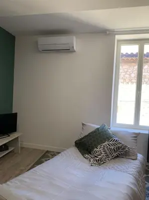 a white bedroom with a bed and a window at Appartement cœur de village Numéro2 in Peyriac-de-Mer