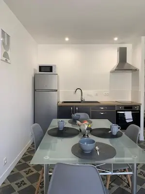 a kitchen with a table and chairs in a kitchen at Appartement cœur de village Numéro2 in Peyriac-de-Mer