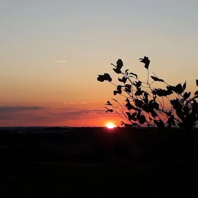 a sunset with the sun setting in the horizon at gite au village in Mourvilles-Hautes