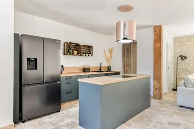 a kitchen with a stainless steel refrigerator and a counter at Grande villa de charme proche de la mer in Peyriac-de-Mer