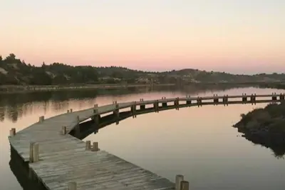a wooden bridge over a body of water at Grande villa de charme proche de la mer in Peyriac-de-Mer