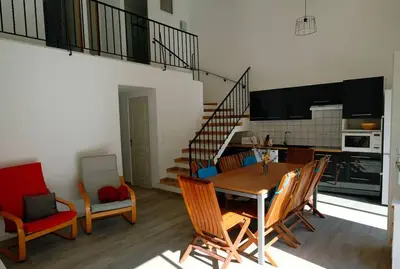 a kitchen and dining room with a table and chairs at Maison confortable à 10 km des plages de la Méditerranée au bord du village pittoresque in Treilles