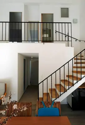 a staircase in a house with a blue chair at Maison confortable à 10 km des plages de la Méditerranée au bord du village pittoresque in Treilles