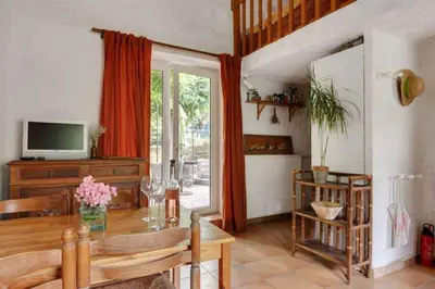 a living room with a wooden table and a television at Gîte vigneron in Félines-Minervois