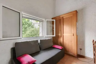 a couch sitting in a room with a window at Gîte vigneron in Félines-Minervois