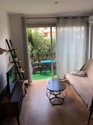 a living room with a bed and a coffee table at Appartement rénové RDC terrasse 200m plage in Port-la-Nouvelle