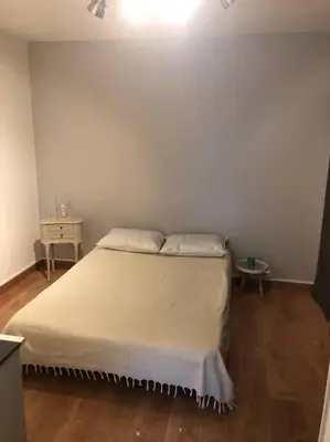 a bedroom with a white bed and a table at Appartement rénové RDC terrasse 200m plage in Port-la-Nouvelle