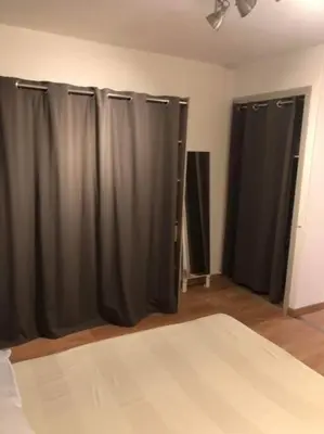 a bedroom with black curtains in a room at Appartement rénové RDC terrasse 200m plage in Port-la-Nouvelle