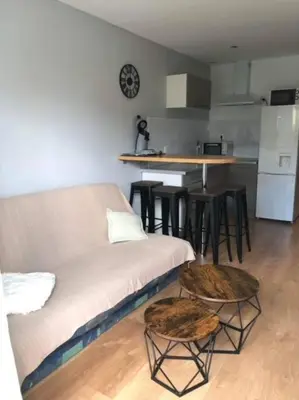 a living room with a couch and a kitchen at Appartement rénové RDC terrasse 200m plage in Port-la-Nouvelle