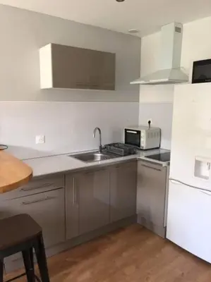 a kitchen with a sink and a white refrigerator at Appartement rénové RDC terrasse 200m plage in Port-la-Nouvelle